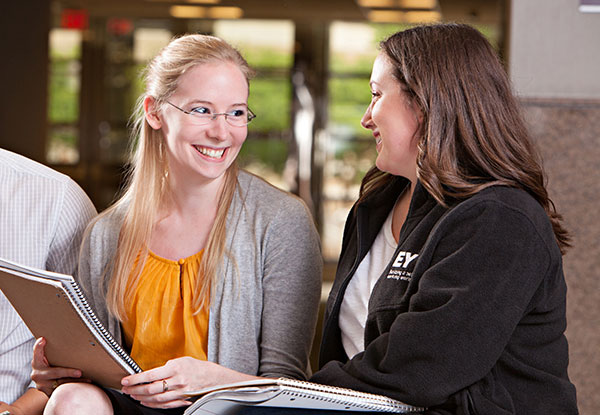A student smiles while talking with an advisor.